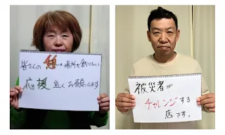 立ち上げメンバー2人が手書きのメッセージボードを掲げている。「皆さんの憩いの場所を創りたい」「被災者がチャレンジする店です」